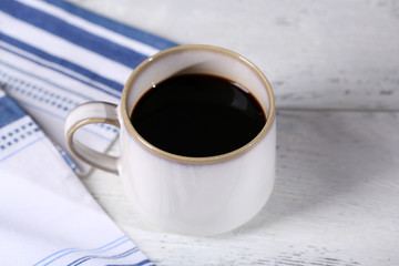 Cup with hot coffee on color  wooden background