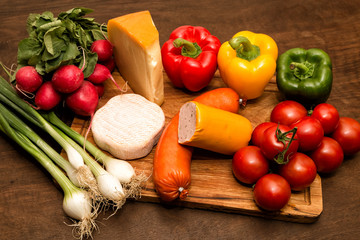 paprika, radieschen und essen auf holzbrett