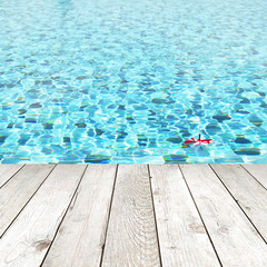 Wood plank on swimming pool water background - spa concept