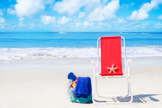 Beach chair with starfish and bag by the ocean