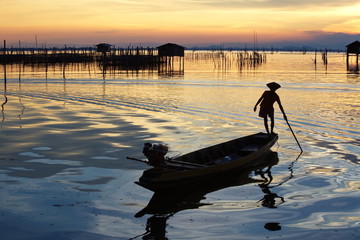 silhouette of fishermen with yellow and orange sun