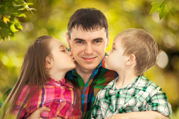 Fototapeta premium Happy doughter and son kissing their father