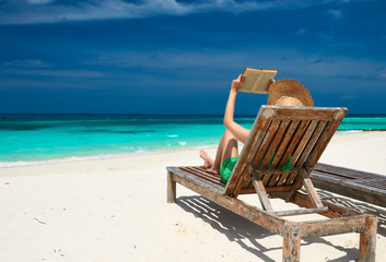 Young woman reading a book at beach