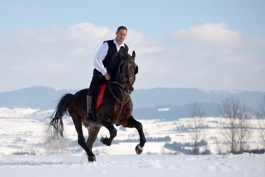 Young Man Riding Horse Outdoor In Winter