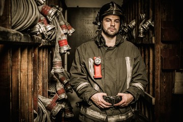 Fototapeta premium Firefighter in storage room with fire hoses