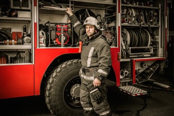 Fireman taking equipment from firefighting truck