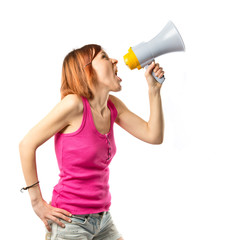 Naklejka premium Redhead girl shouting with a megaphone over white background