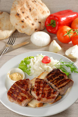 Grilled steaks on toast bread, served with onion and vegetable