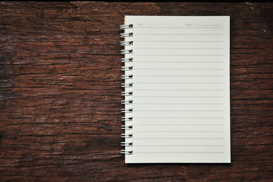 Brown notebook on a wood background