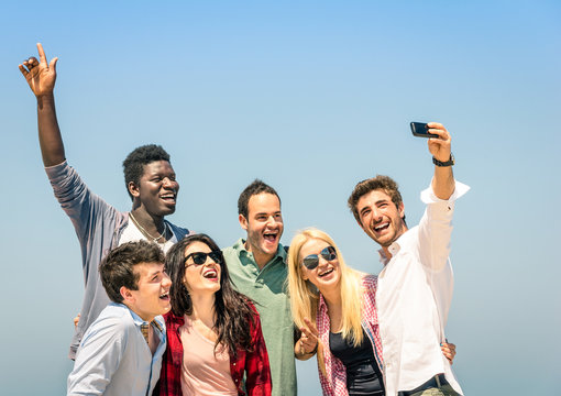Group of multiracial friends taking a selfie on the blue sky