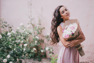 beautiful girl with a bouquet of peonies