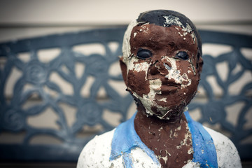 Closeup of Peeling Painted Statue of Black Boy