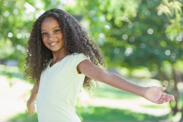 Young girl smiling at the camera with arms outstretched