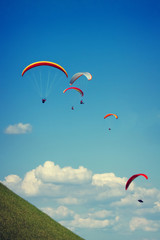 Paraglider flying against the czech central mountains
