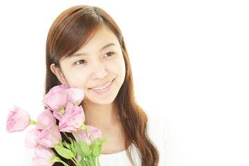 Obraz na płótnie Canvas 花を持つ笑顔の女性