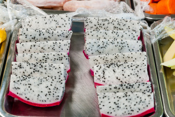 Pieces of fresh dragon fruit prepare to eat on market stand.