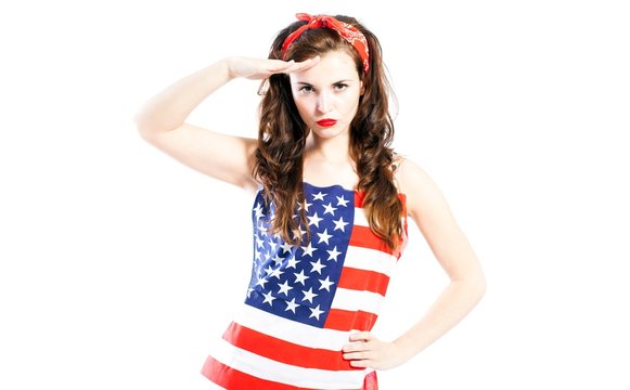 Pin up girl wrapped in american flag saluting
