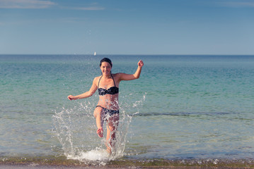 Glückliche Frau spritzt mit Wasser