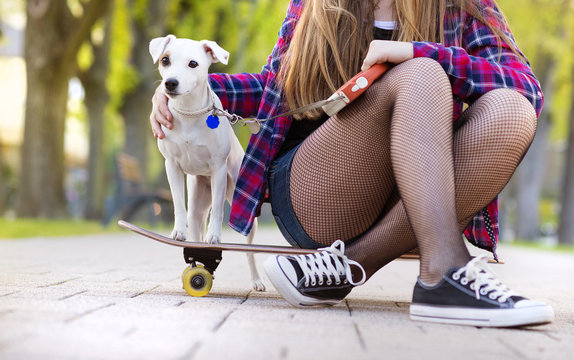 Teenage Girl With Skateboard And Dog