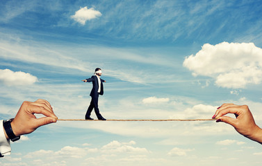 man with closed eyes balancing on the rope