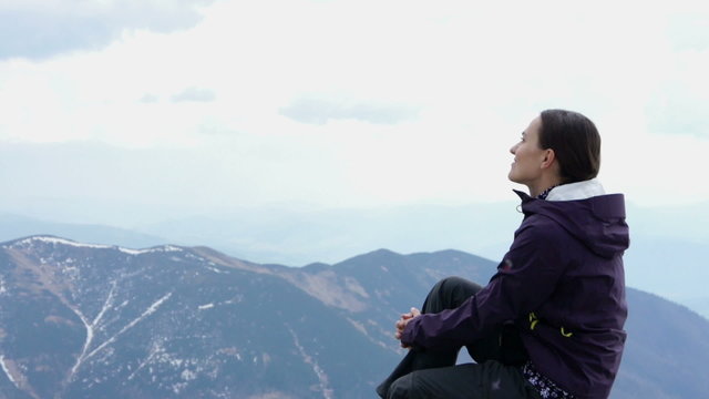 Woman at the mountain peak looking at beautiful view