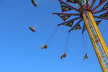 Flying swing carousel against blue sky