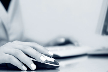 Female hands using computer mouse and keyboard