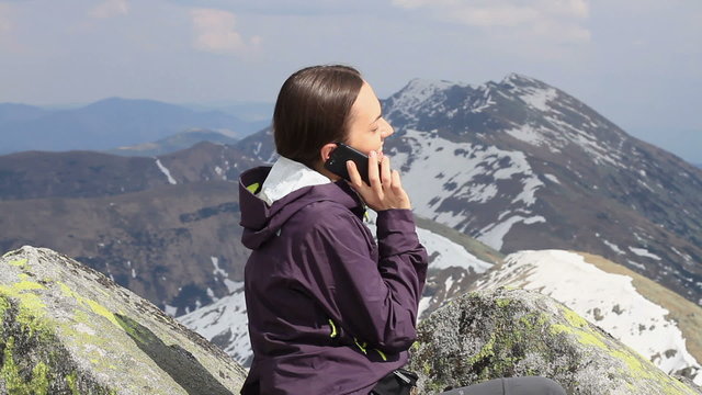 Attractive woman talking on cellphone in the mountains