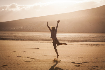 young man jumping happy in the desert