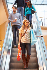 Female Shopper On Escalator In Shopping Mall