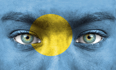 Human face painted with flag of Palau