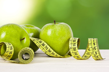 Fototapeta green apples with tape measure, concept of healthy diet obraz