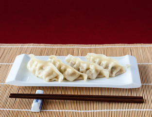 Gyoza or Potstickers on Bamboo Mat with Copy Space