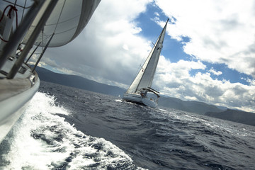 Sailing yachts in the sea at race in stormy weather.