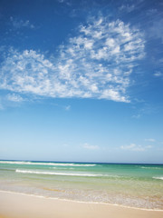 Fototapeta na wymiar tropical beach with clouds creating a heart shape in the sky