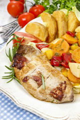Joint of pork with baked potatoes and fresh vegetables