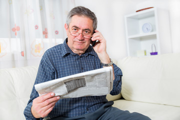 elderly man reading his newspapers