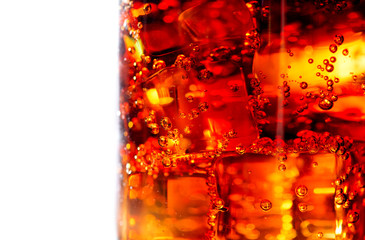 Cola with ice and bubbles in glass closeup