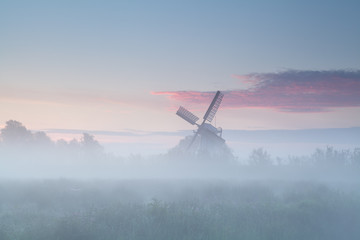 Fototapeta na wymiar windmill in dense morning fog
