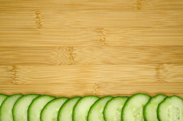 Slices of cucumber on wooden background