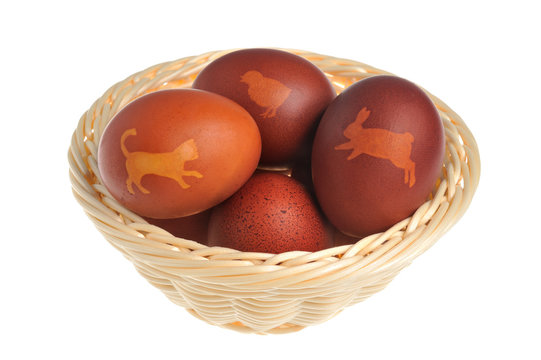Decorated easter eggs in wicker basket isolated