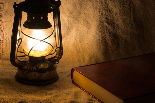 Set with an old rusty lantern and a book