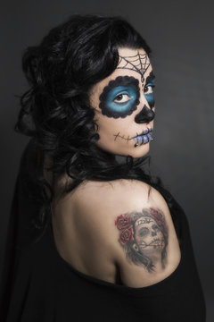 Junge Frau mit Sugar Skull Make up und Tattoo