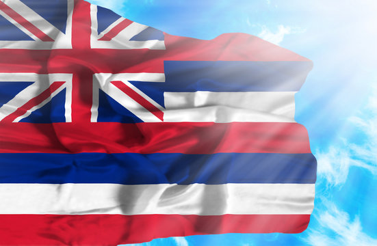 Hawaii waving flag against blue sky with sunrays