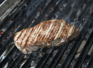beef steak cooking on an open flame grill