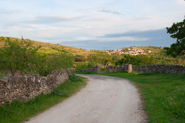 Rural road in a little town between the meadows