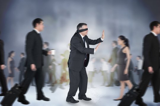 Composite image of mature businessman in a blindfold