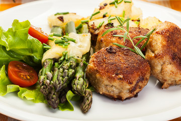 Meatballs served with boiled potatoes and asparagus