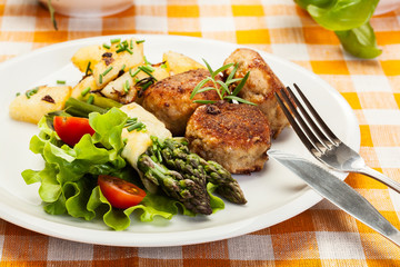 Meatballs served with boiled potatoes and asparagus