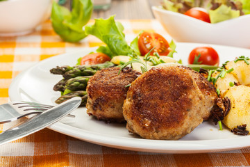 Meatballs served with boiled potatoes and asparagus